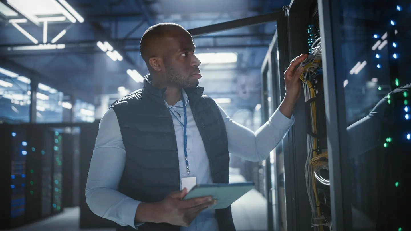 Data-centre technician checking server and network infrastructure