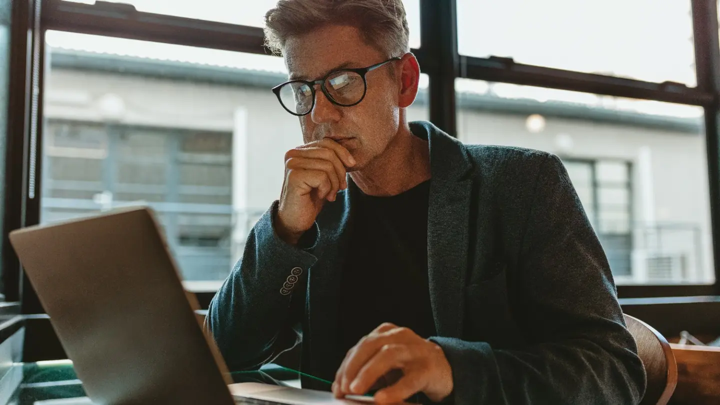 Business professional reviewing a laptop for performance and suitability