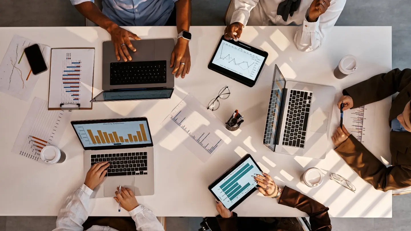 Business team using laptops and tablets to work with data